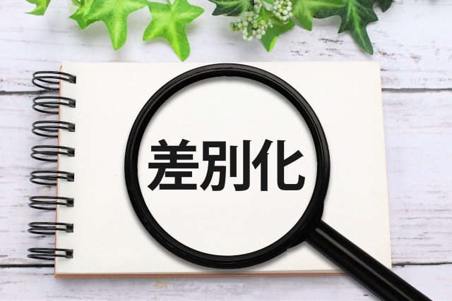 差別化を示すノートと虫眼鏡