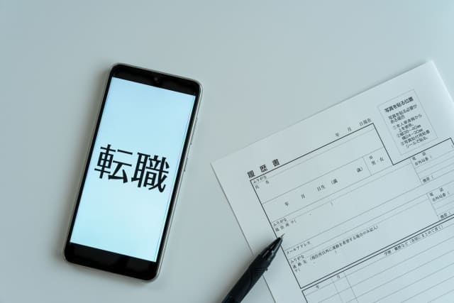 転職と表示されたスマホ画面と書類でのQRコード
